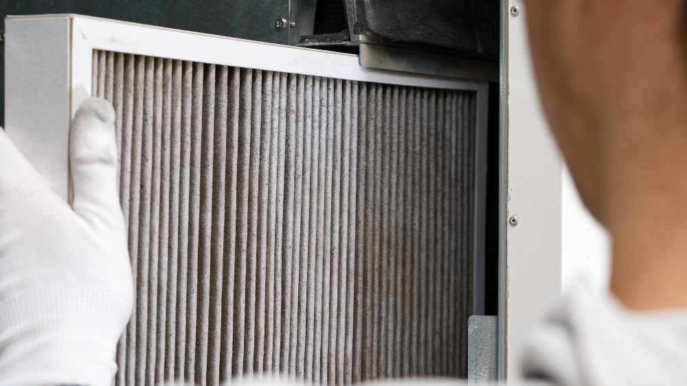 over the should image of a dirty AC air filter being removed, ac air filters for Corpus Christi