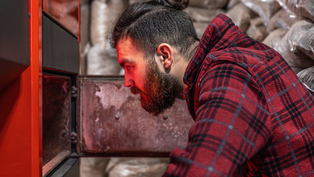 a man looking at a boiler to improve his heating system in a home