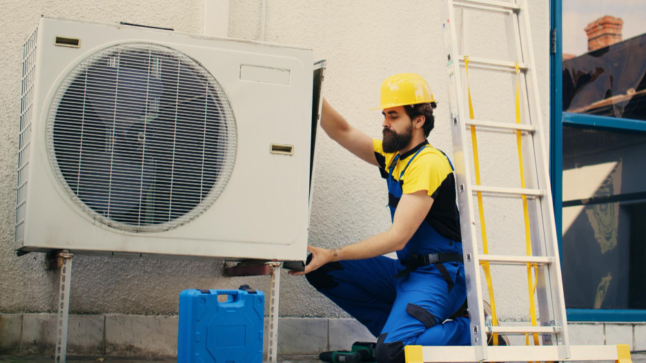 Technician inspecting a mini-split HVAC unit, explaining “how long do a mini splits last”.